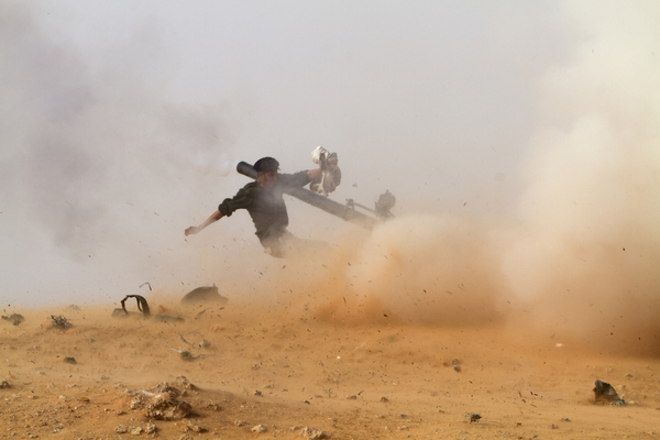 Un combatiente libio anti-gobierno apunta su arma ante el acercamiento de las fuerzas pro-Jaddafi (2011)